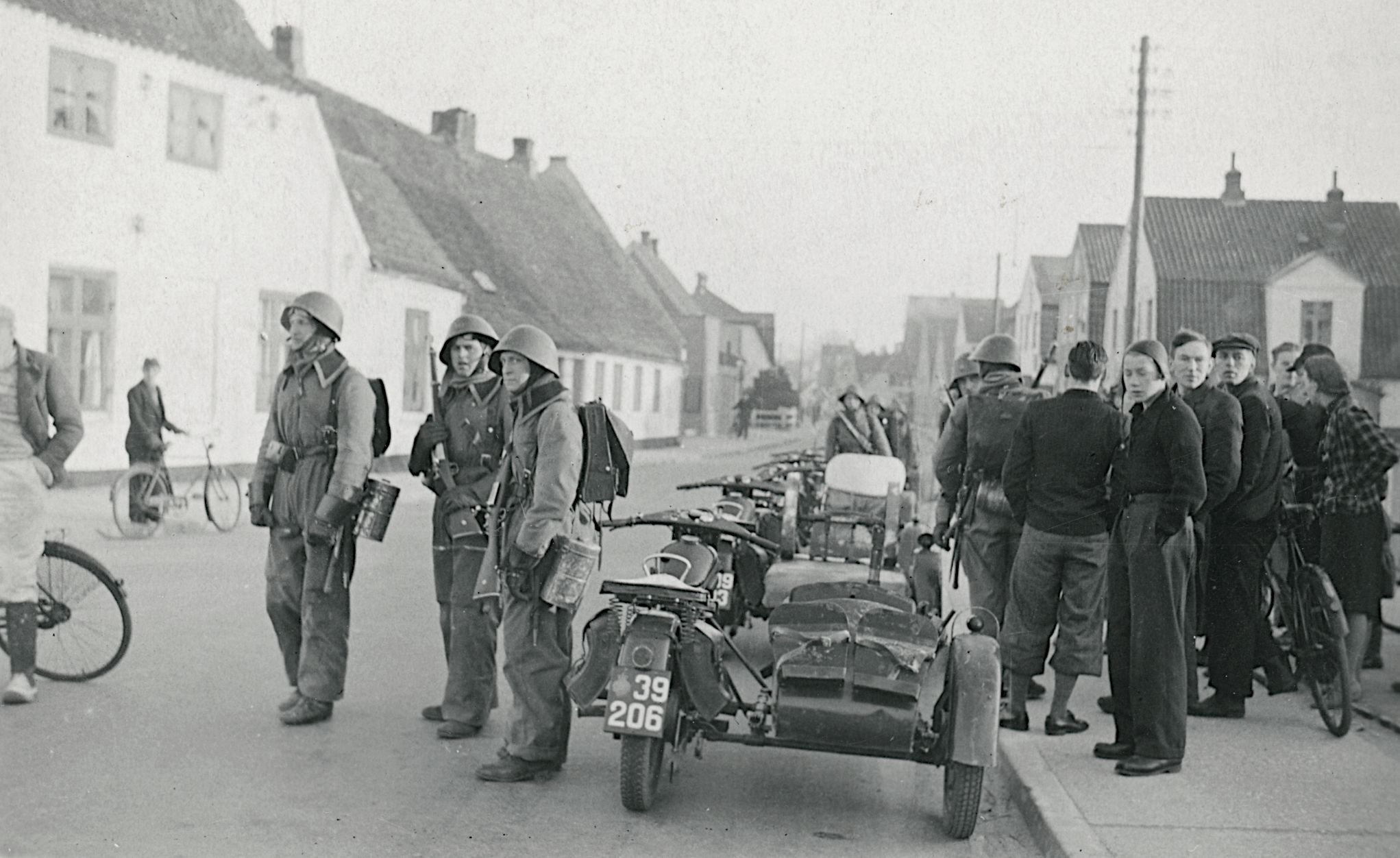 På billedet her taget om morgenen den 9. april 1940 ser du danske motorcykelpatruljer i Aabenraa. Fotokilde: Nationalmuseet, Danmark. Licens ifølge Nationalmuseet: No known rights. Fotograf: Ikke oplyst.